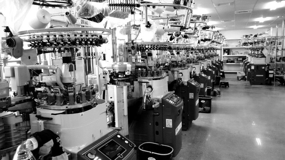 Circular sock knitting machines with yarn feeders and production controls